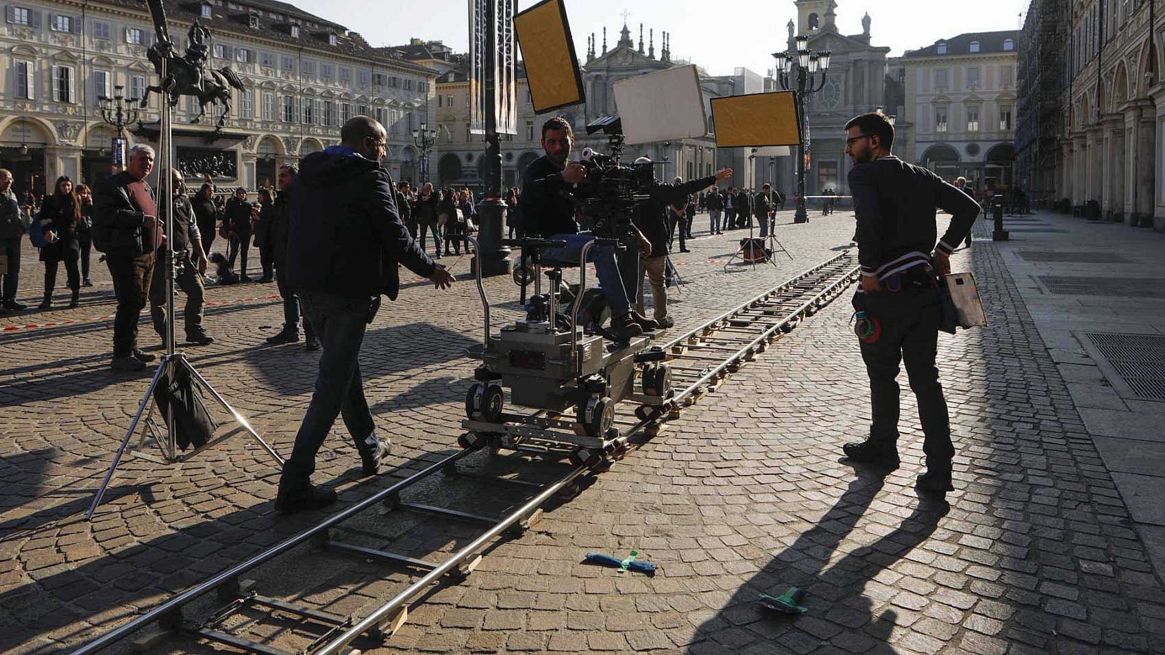 fotografia di reportage per il cinema regista dà indicazioni su set film in piazza san carlo a Torino