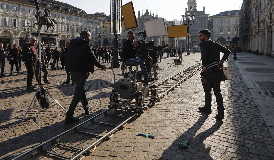 fotografia di reportage per il cinema regista dà indicazioni su set film in piazza san carlo a Torino